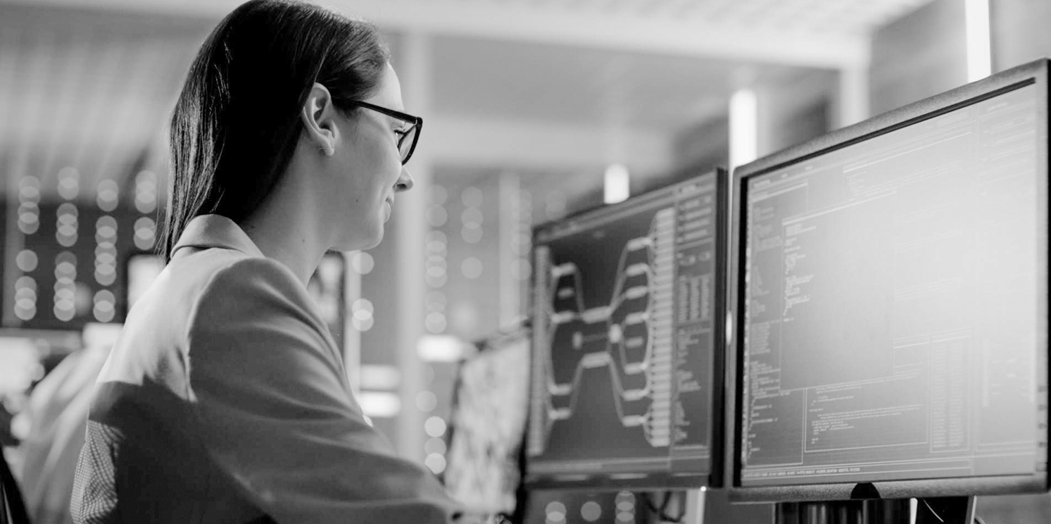 Woman at computer monitoring displays.